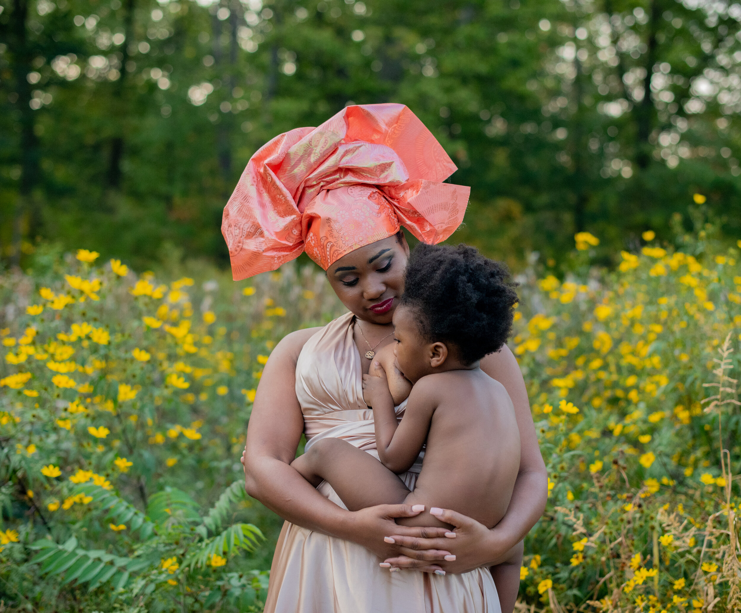 mother breastfeeding her two year old in a field of yellow flowers in lakewood ohio