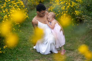 black mother breastfeeding child outside in a field of yellow flowers in lakewood ohio