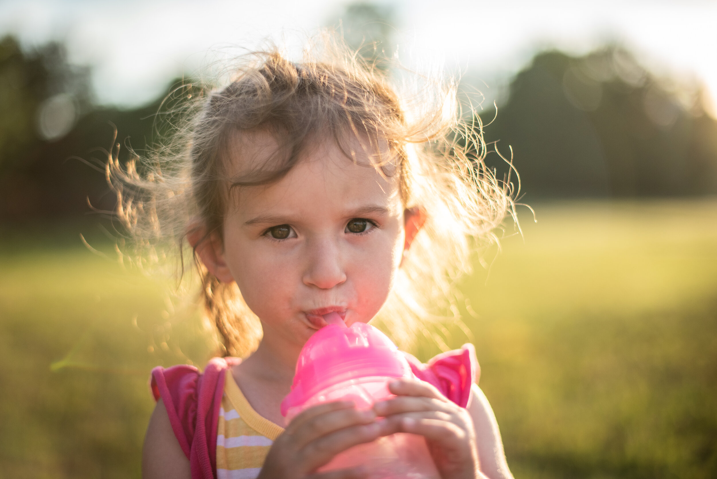 little girl drinking her pink water bottle outside at sunset in strongsville ohio