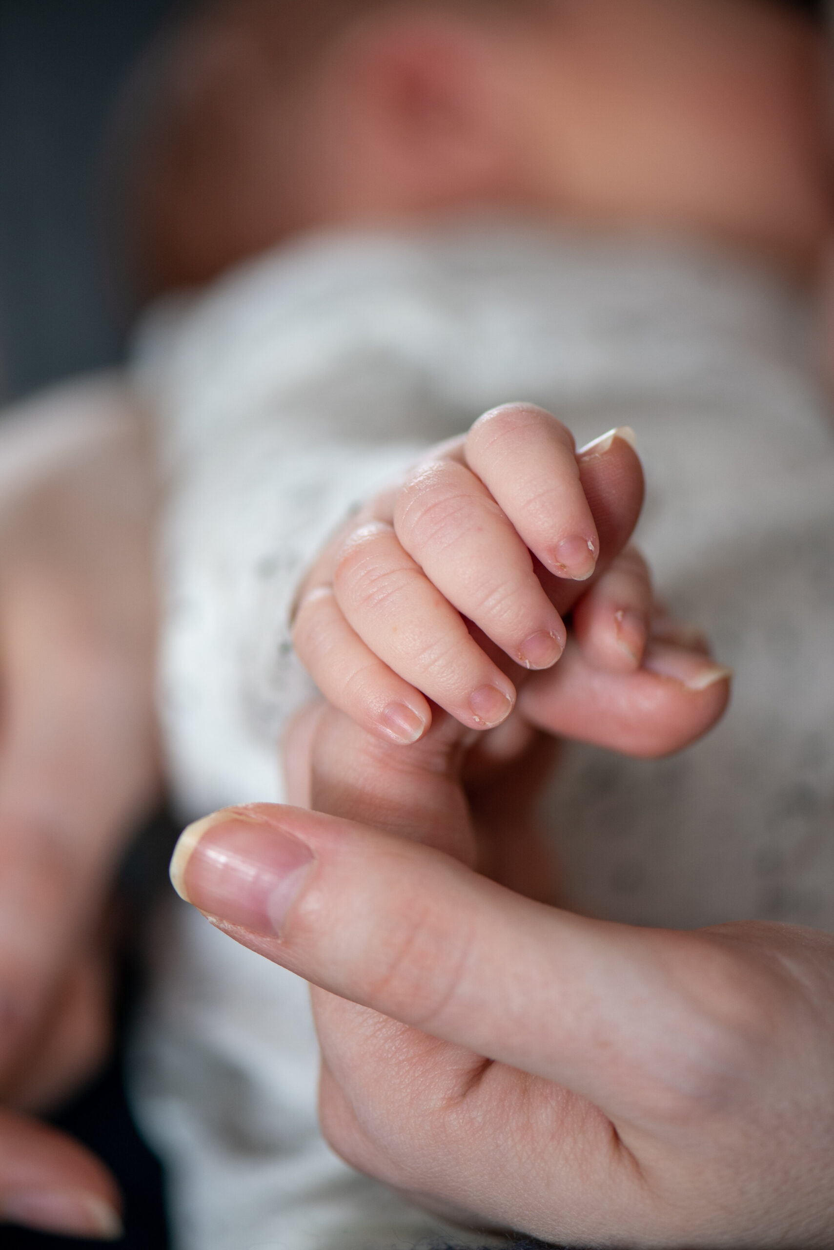 baby holding onto mothers' finger