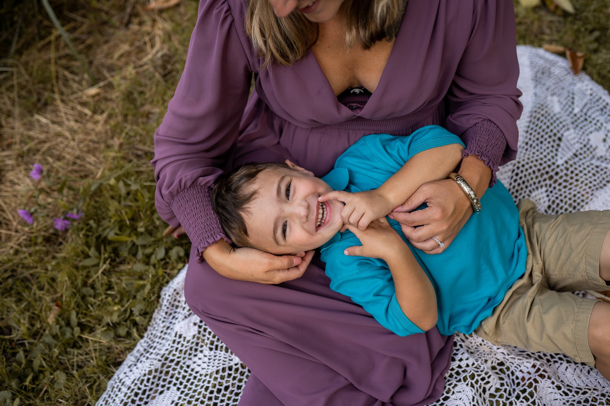 boy smiling and laying head on moms lap