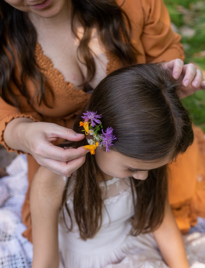 mother putting flowers in daughters hair
