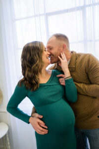 pregnant mom laughing with father while holding belly