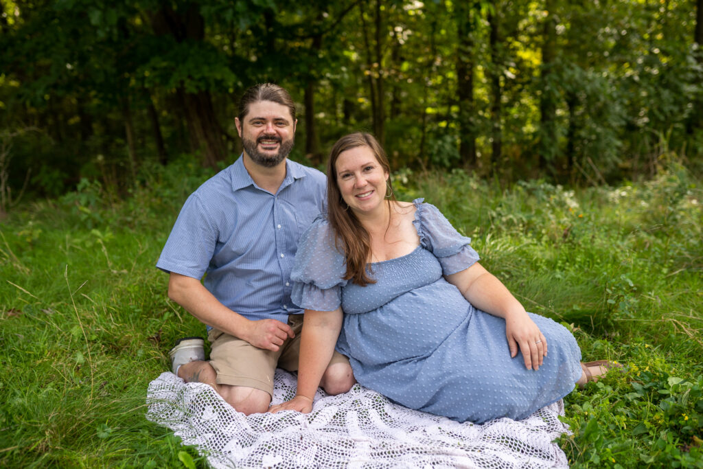 mom and dad sitting on a crocheted blanket on the grass with outfits from old navy cleveland