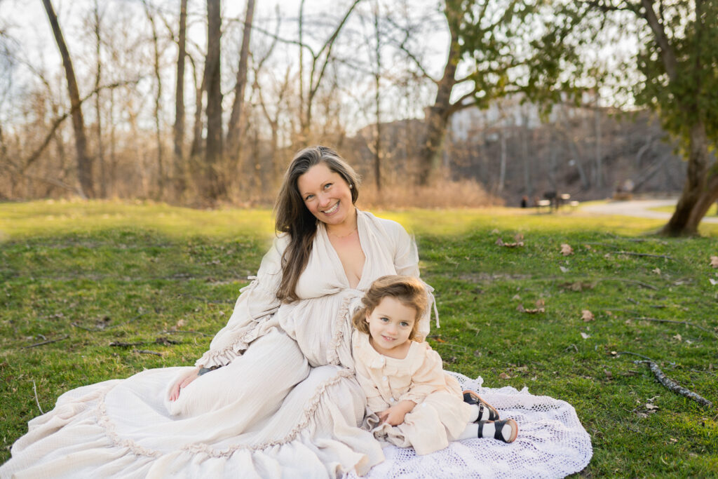 madison hendry sitting with her daughter on a blanket in the grass smiling at the camera in cleveland ohio